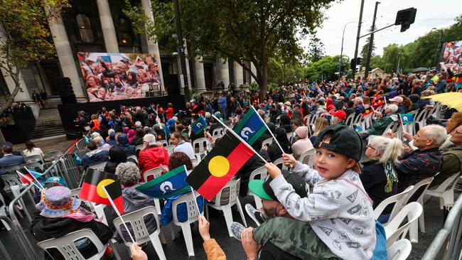 A child holds Aboriginal and Torres Strait Island flags during a ceremony in Adelaide.