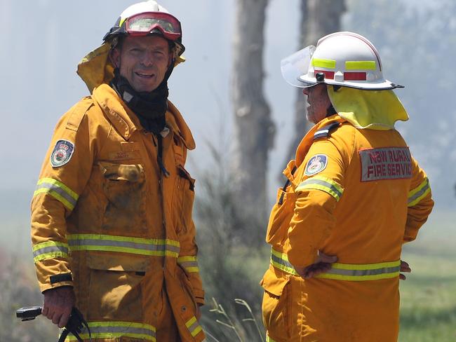 Tony Abbott (left) seen here last year near Port Stephens, regularly downplays his volunteer work with the RFS. Picture: Dan Himbrechts