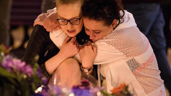 MANCHESTER, ENGLAND - MAY 23:  A woman is consoled as she looks at the floral tributes following an evening vigil outside the Town Hall on May 23, 2017 in Manchester, England. An explosion occurred at Manchester Arena as concert goers were leaving the venue after Ariana Grande had performed. Greater Manchester Police are treating the explosion as a terrorist attack and have confirmed 22 fatalities and 59 injured.  (Photo by Leon Neal/Getty Images)