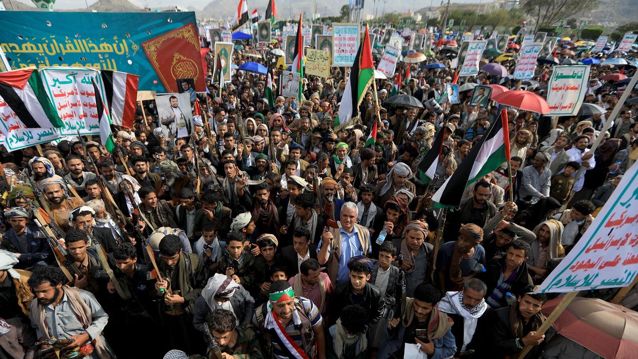 Yemenis lift placards and wave Palestinian flags as they march in the Huthi-run capital in solidarity with the people of Gaza. Picture: AFP