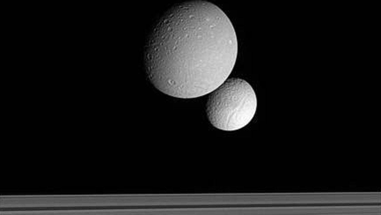 The Cassini spacecraft has captured a striking image of Saturn's moons Dione and Tethys passing each other across the planet's ring system.