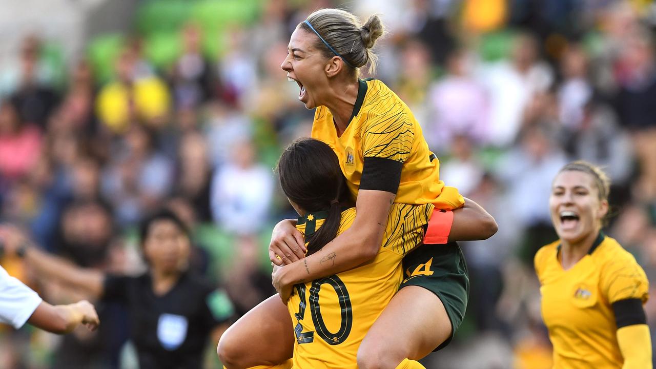 Alanna Kennedy (C) leaps into the arms of teammate Sam Kerr. (Photo by WILLIAM WEST / AFP)