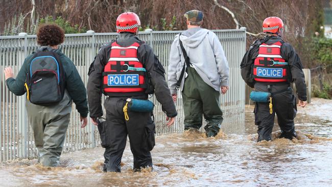 Police escort Traralgon residents back to their flooded homes. Picture: David Caird