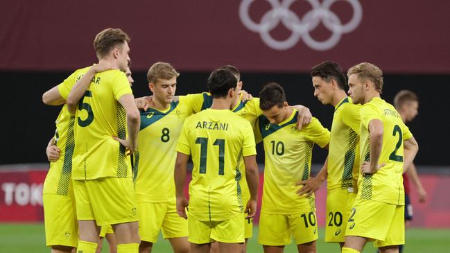 Australia's starting players gather on the pitch prior to their Tokyo 2020 Olympic Games men's group C first round football match between Australia and Spain at Sapporo Dome in Sapporo on July 25, 2021. (Photo by ASANO IKKO / AFP)