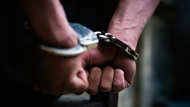 Man on the chair in Handcuffs. Rear view and Closeup ,Men criminal in handcuffs arrested for crimes. With hands in back,boy  prison shackle in the jail violence concept. - istock