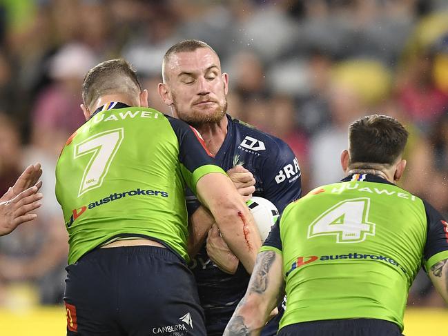 Coen Hess of the Cowboys is tackled by George Williams and Curtis Scott of the Raiders during the round seven NRL match between the North Queensland Cowboys and the Canberra Raiders at QCB Stadium. (Photo by Ian Hitchcock/Getty Images)