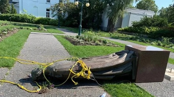 The statue of Queen Elizabeth lies on the ground after being toppled.