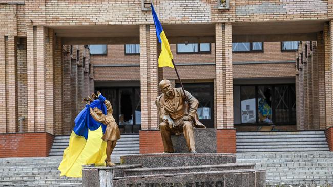 Ukrainian flags placed on statues in a square in Balakliya, Kharkiv region, amid the Russian invasion of Ukraine.