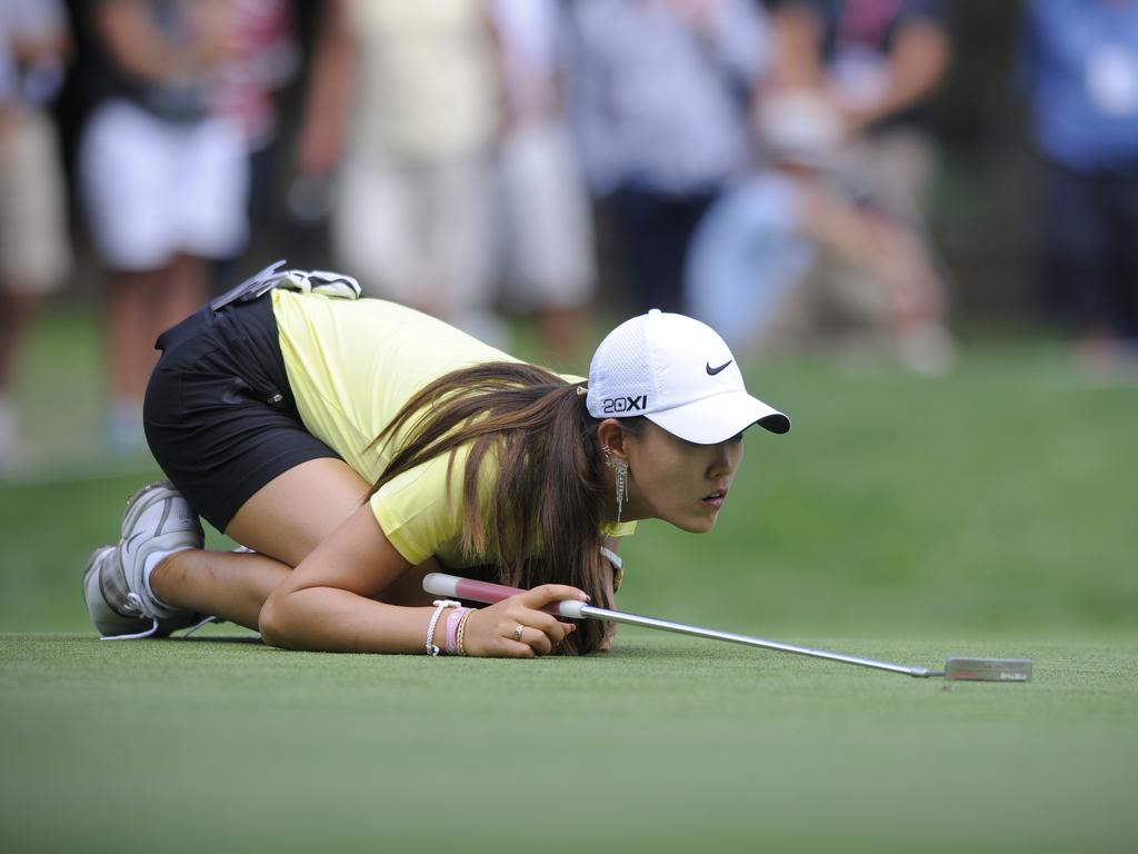 American golfer Michelle Wie inspects the terrain of the green.