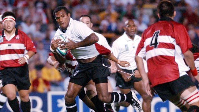 Fiji’s Epeli Ruivadra hangs on by a thread as he looks for a gap in Japan's defence during the Rugby World Cup game in Townsville in 2003. Picture: AP Photo/Michael Chambers