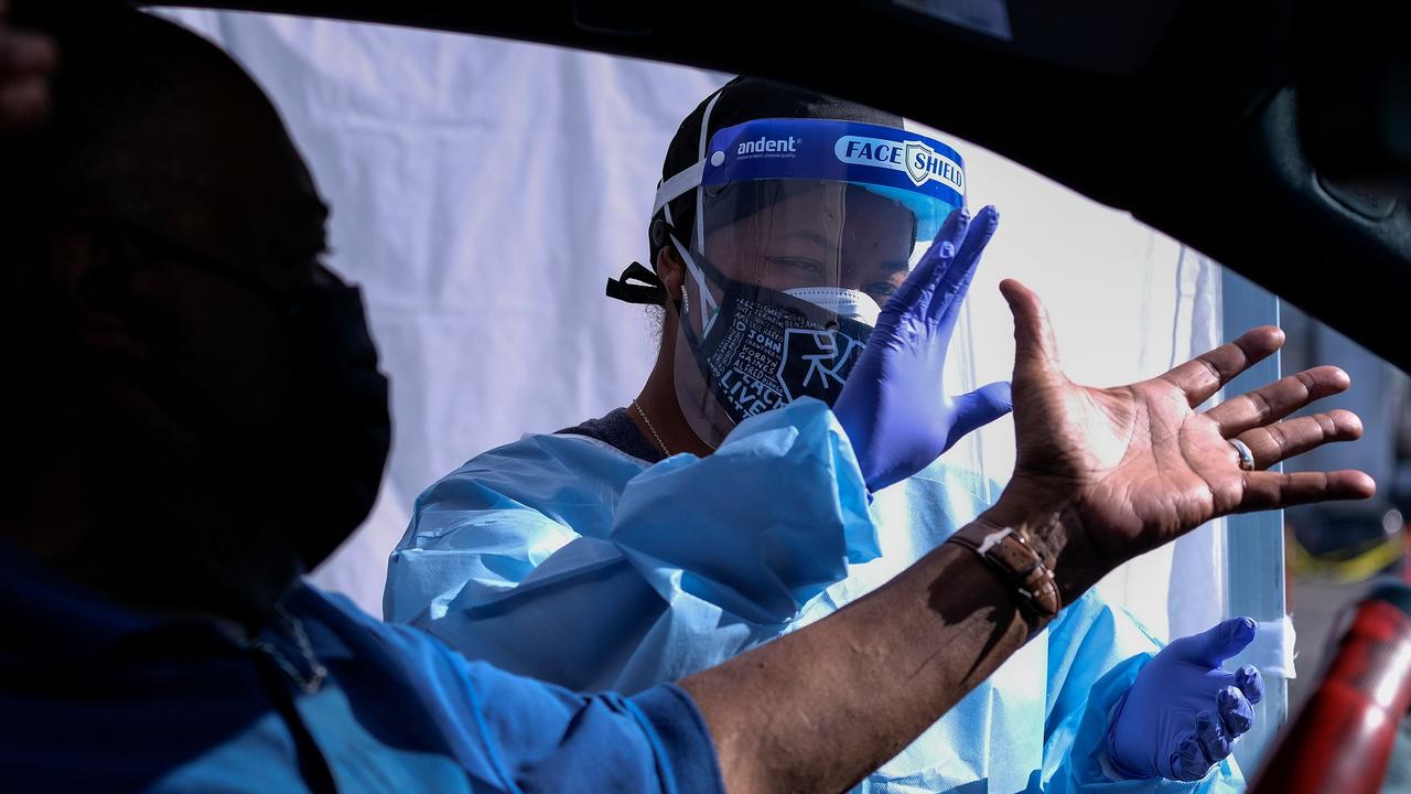 A healthcare worker greets a motorist at the Southside Church of Christ in Los Angeles. Picture: Ringo Chiu / AFP)