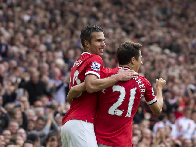 Manchester United's Robin van Persie, left, celebrates with teammate Abder Herrera after scoring against against West Ham United during their English Premier League soccer match at Old Trafford Stadium, Manchester, England, Saturday Sept. 27, 2014. (AP Photo/Jon Super)