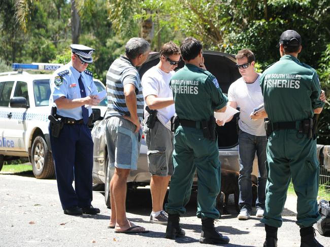 NSW Fisheries officers with a Mogo man accused of abalone trafficking.