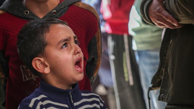 A young boy cries after family were killed. Picture: Getty Images