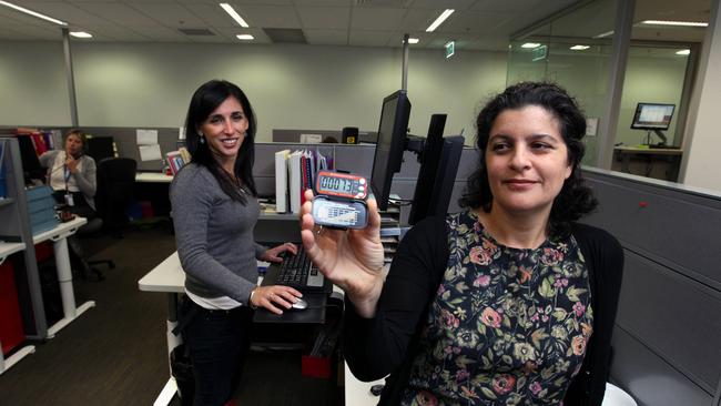 Obesity expert Professor Anna Peeters demonstrates a standing office desk and a pedometer. Picture News Corp.