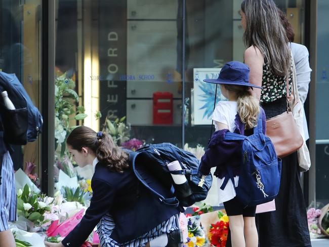 St Andrew's Cathedral School students lay flowers outside the school in memory of Lilie James after her death. Picture: Rohan Kelly