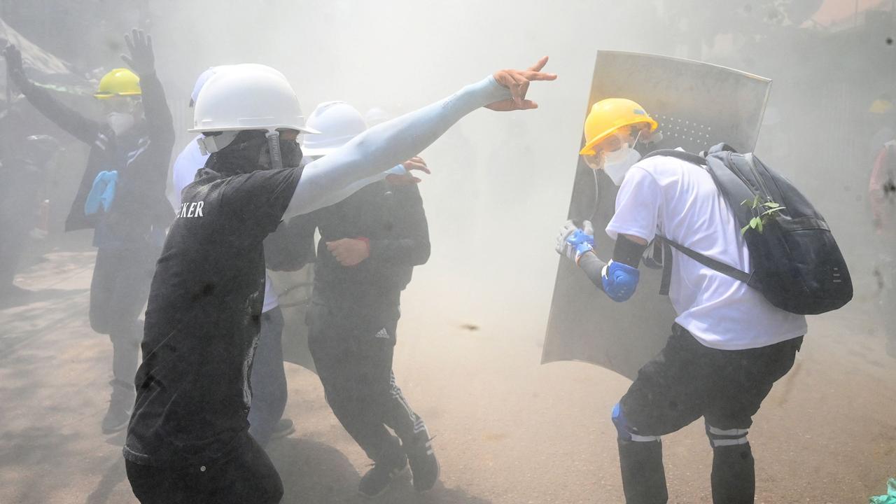 Protesters react after tear gas is fired by police during a demonstration against the military coup in Yangon on March 7, 2021. Picture: STR/AFP