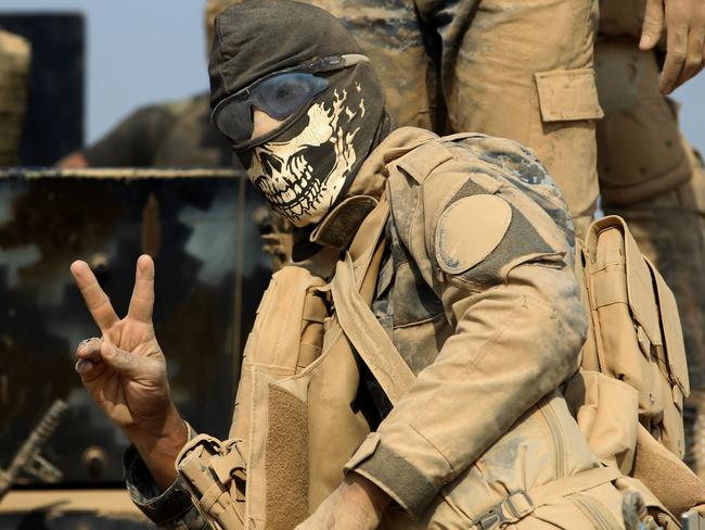 A member of the Iraqi government forces flashes the sign for victory. Picture: AFP PHOTO/AHMAD AL-RUBAYE