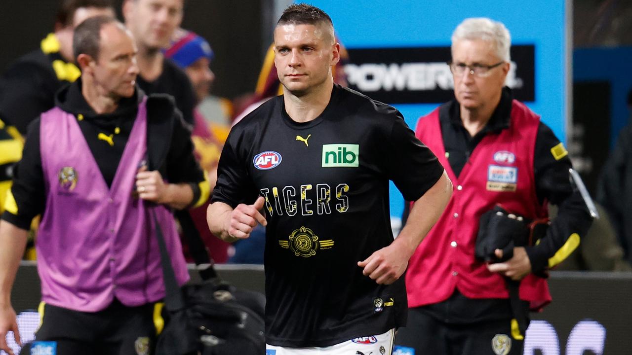 Injured Tiger Dion Prestia leaves the field with medical staff. Picture: Michael Willson