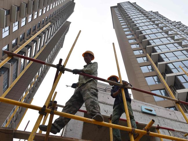 Construction workers assemble scaffolding on a housing complex in Beijing on August 15, 2017.  China's massive debt is on a "dangerous" path, raising the risk of a sharp slowdown in growth, the IMF warned on August 15, urging Beijing to speed up structural reforms. / AFP PHOTO / Greg Baker