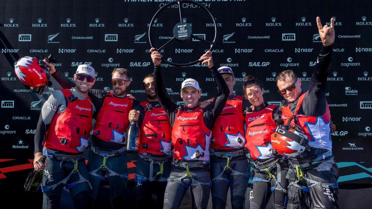 Phil Robertson (centre), driver of Canada SailGP Team, lifts the trophy with his teammates after winning SailGP New Zealand. (Photo by FELIX DIEMER / SailGP / AFP)