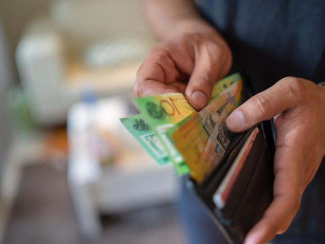 a male taking money out of a wallet, Australian cash generic spending