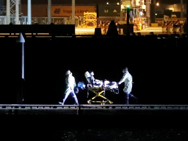 Coronavirus patients being transferred from the Ruby Princess cruise ship to waiting ambulances at Foreshore Road Boat Ramp in Botany. Picture: Jonathan Ng