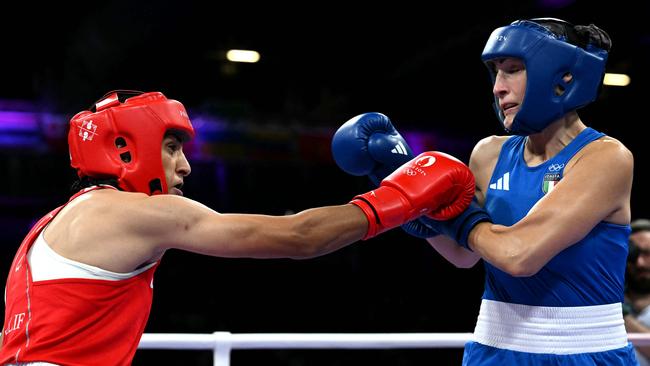 Algeria's Imane Khelif (in red) punches Italy's Angela Carini. (Photo by MOHD RASFAN / AFP)