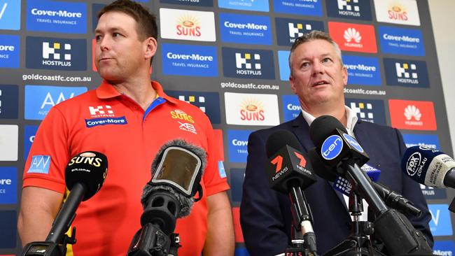 Gold Coast coach Stuart Dew (left) and chief executive Mark Evans face the media.