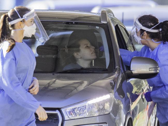 BRISBANE, AUSTRALIA - NewsWire Photos - AUGUST 5, 2021. A health worker swabs a member of the public at a pop up Covid-19 testing clinic at Indooroopilly State High School in Brisbane, as Queensland battles through a Delta variant outbreak of coronavirus.Picture: NCA NewsWire / Dan Peled