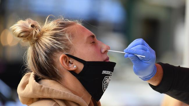 A medical worker takes a nasal swab sample from a student to test for COVID-19. Picture: AFP