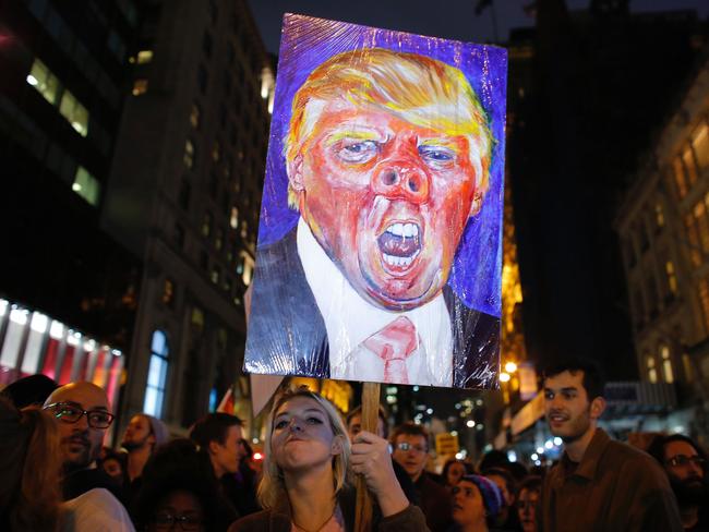 A woman holds a poster as she takes part in a protest against President-elect Donald Trump in New York City on November 9, 2016. Picture: AFP
