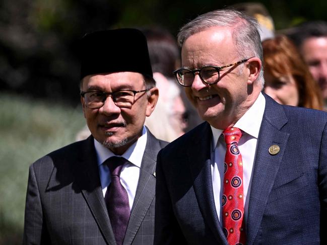 Malaysia's Prime Minister Anwar Ibrahim (C) introduces Australia's Prime Minister Anthony Albanese (R) to the Malaysian delegation during the Australia-ASEAN (Association of Southeast Asian Nations) summit in Melbourne on March 4, 2024. (Photo by William WEST / AFP)