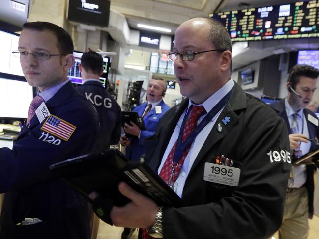 Trader Jeffrey Vazquez, center, works on the floor of the New York Stock Exchange, Monday, April 11, 2016. U.S. stocks opened higher on Wall Street following gains overseas as investors held out hope for more economic stimulus from China. (AP Photo/Richard Drew)