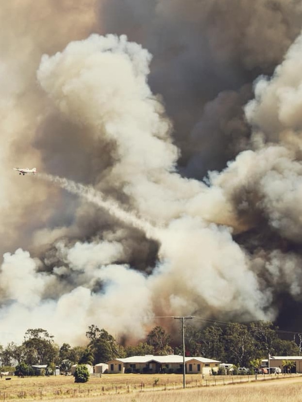 Aircraft waterbombs amid thick smoke on Barmaryee Road. Picture: Cassie Groves