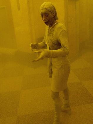 Marcy Borders takes refuge in an office building. She was caught outside on the street as the cloud of smoke and dust enveloped the area. Picture: Stan Honda