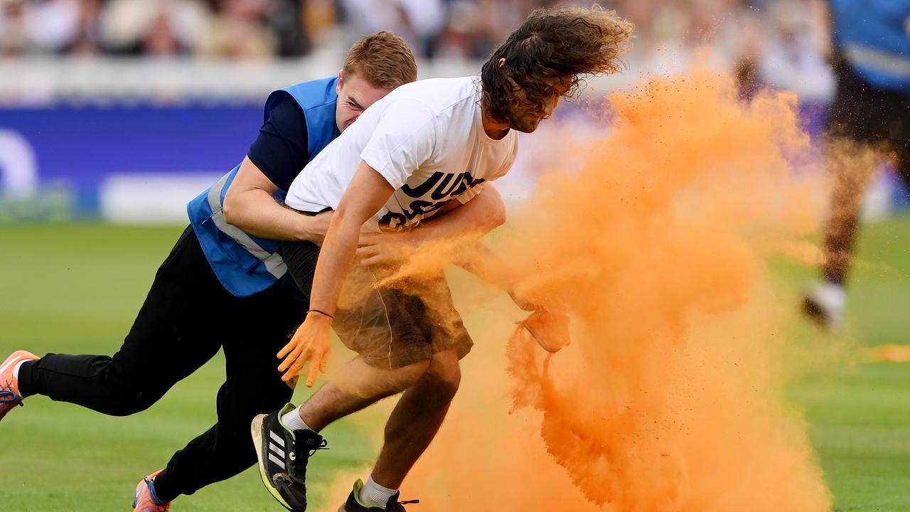 A Just Stop Oil protester is tackled by security during Day One of the Ashes 2nd Test match between England and Australia at Lord's Cricket Ground on June 28, 2023. (Photo by Stu Forster/Getty Images)