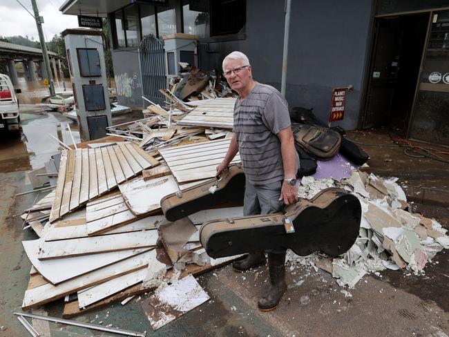 Planet Music owner Peter Miller discards destroyed items in Lismore. Picture: Toby Zerna