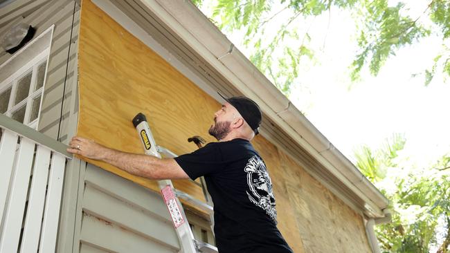 Doug Shobbrook from Redcliffe, using plywood to cover windows on a house. Photo Steve Pohlner