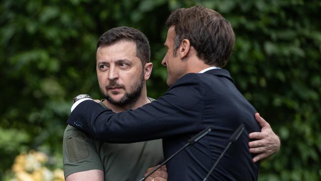 Ukrainian President Volodymyr Zelensky and France’s President Emmanuel Macron shake hands and hug after a press conference. (Photo by Alexey Furman/Getty Images)