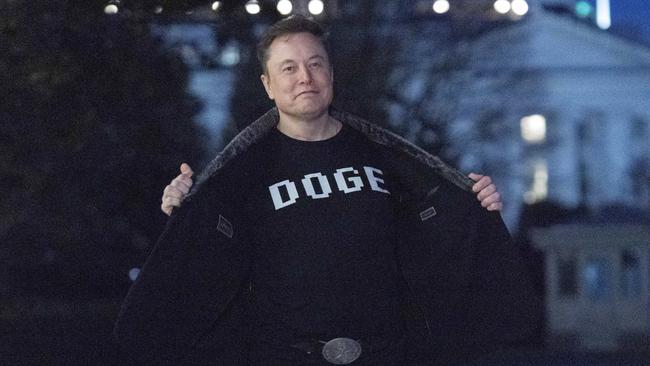 Elon Musk flashes his T-shirt that reads 