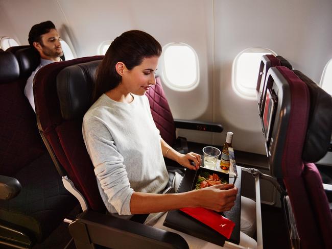 Qantas economy passenger Gabrielle Jervis enjoying a meal on board an A330. Picture: Anson Smart, Brent Winstone