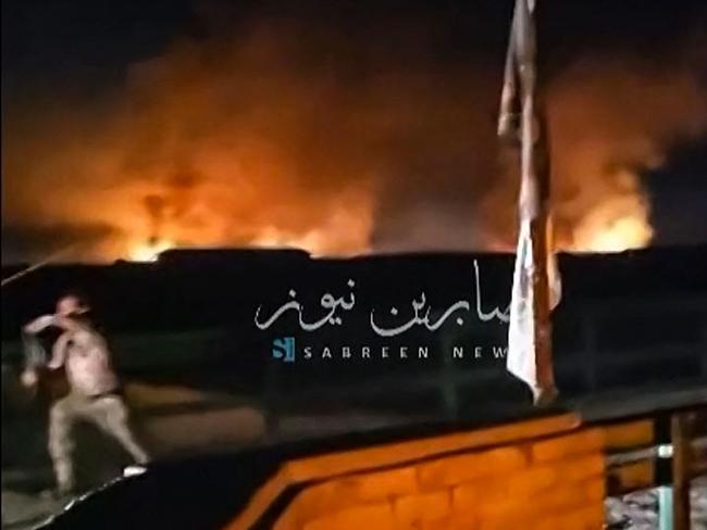 This image grab from a UGC video posted on April 20, 2024, shows fire and smoke rising in the central province of Babylon after an alleged bombing overnight on an Iraqi military base housing a coalition of pro-Iranian armed groups. The explosion hit the Kalsu military base in Babylon province south of Baghdad, where Iraq's Popular Mobilization Forces, or Hashed al-Shaabi, is stationed, according to an interior ministry source and a military official. (Photo by UGC / AFP) / - NO Resale - NO Internet / / XGTY / XGTY/RESTRICTED TO EDITORIAL USE - MANDATORY CREDIT AFP -  SOURCE: SABREEN NEWS - NO MARKETING - NO ADVERTISING CAMPAIGNS -  DISTRIBUTED AS A SERVICE TO CLIENTS - NO ARCHIVE - AFP IS NOT RESPONSIBLE FOR ANY DIGITAL ALTERATIONS TO THE PICTURE'S EDITORIAL CONTENT -NO USE 10 DAYS AFTER VALIDATION - / BEST QUALITY AVAILABLE