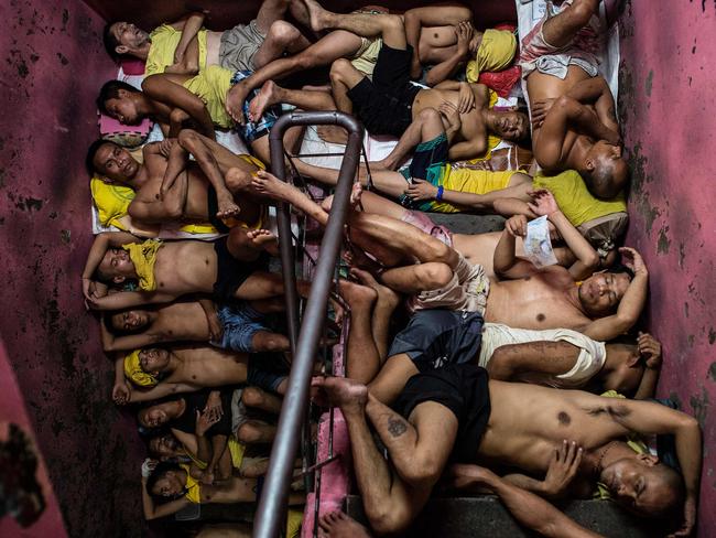 In this photo taken on July 21, 2016 inmates sleep on the steps of a ladder inside the Quezon City jail at night in Manila. There are 3,800 inmates at the jail, which was built six decades ago to house 800, and they engage in a relentless contest for space. Picture: AFP PHOTO / NOEL CELIS