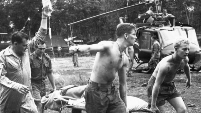 Australian soldiers stretcher a wounded soldier from a helicopter during the Vietnam war.