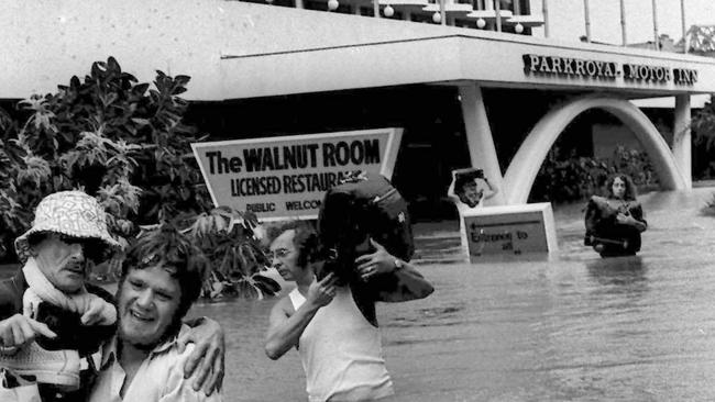 Visitors carry their luggage, and other people, to drier ground in late January 1974.