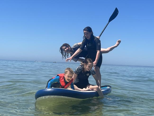 Jade (17), Mikayla (15), Olivia (13), Spencer (9) - all cousins - having a splash in the water and spending quality time together playing on the stand up paddleboard at St Leonards. Picture: Vicki Hallett, Sunbury.