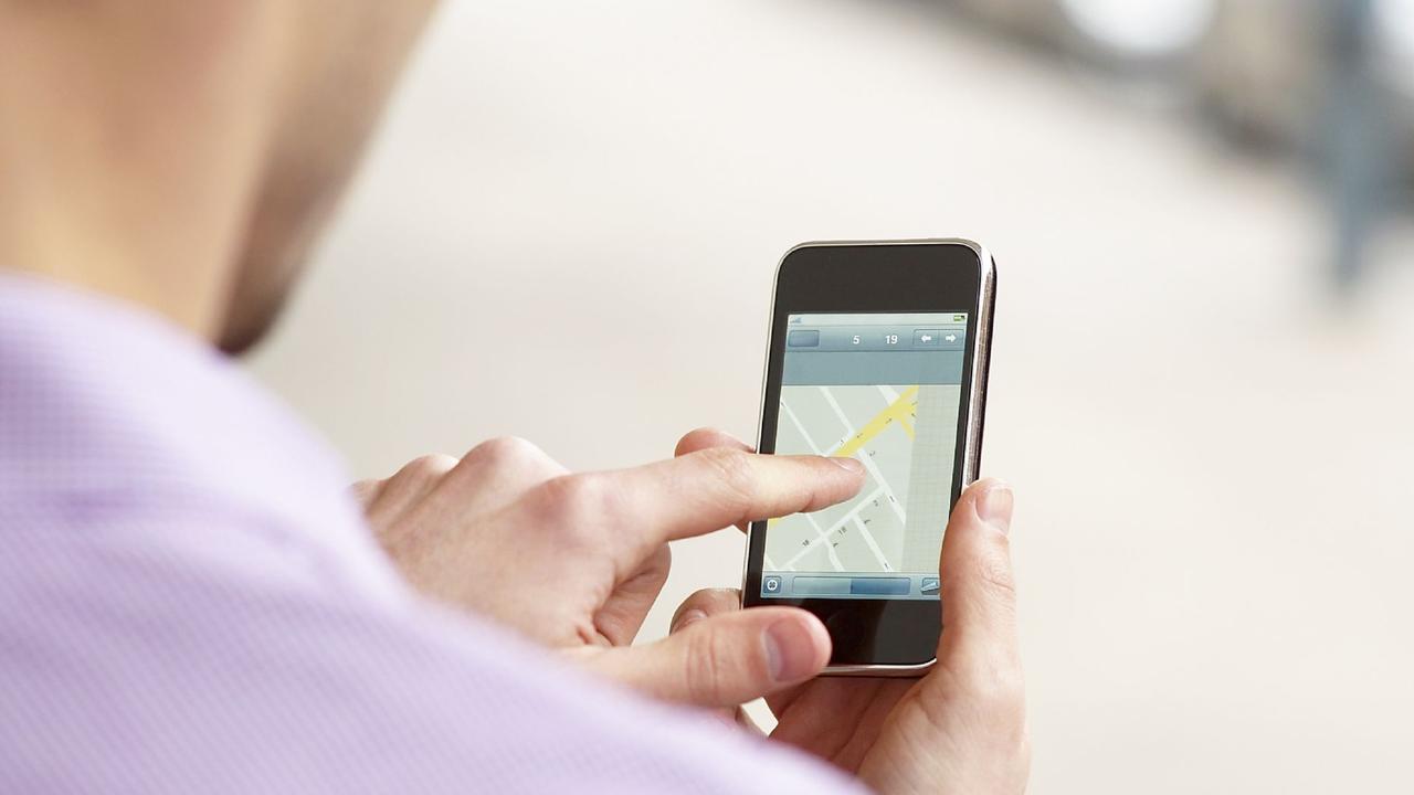 Generic image of smartphone iPhone user. A young man looking for directions on an smart phone.