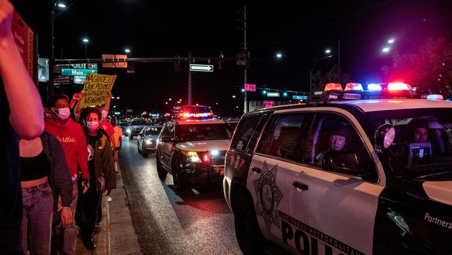 A police officers looks outside the car window as people march, in Las Vegas. Picture: AFP