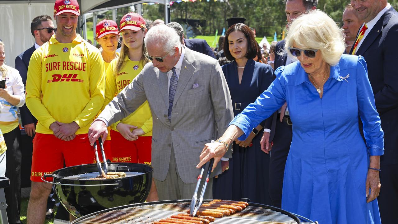 King Charles III and Queen Camilla cook sausages for the food stalls at the Premier's Community Barbeque at Parramatta Park. Picture: Toby Melville-Pool/Getty Images